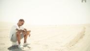 Foto Wesley Sneijder zit op bal in het zand